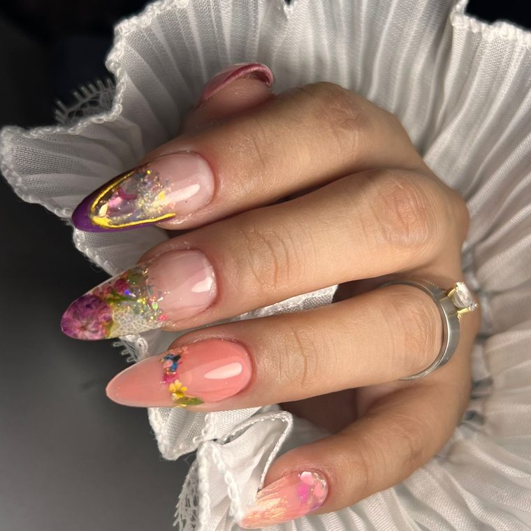 Uñas almendradas con flores encapsuladas y detalle dorado